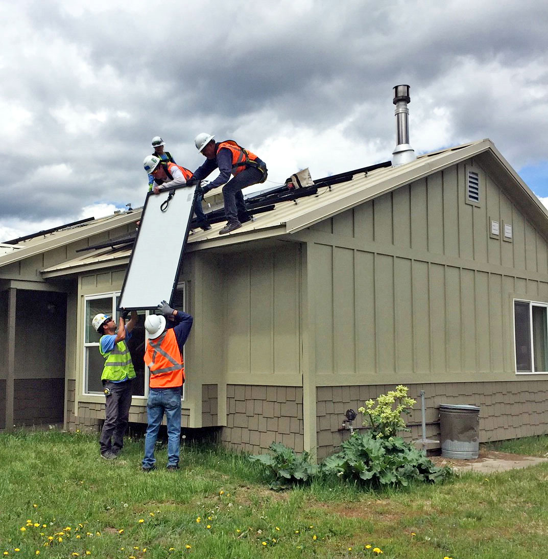 Workers installing rooftop solar panels on a home, illustrating renewable energy incentives listed in DSIRE