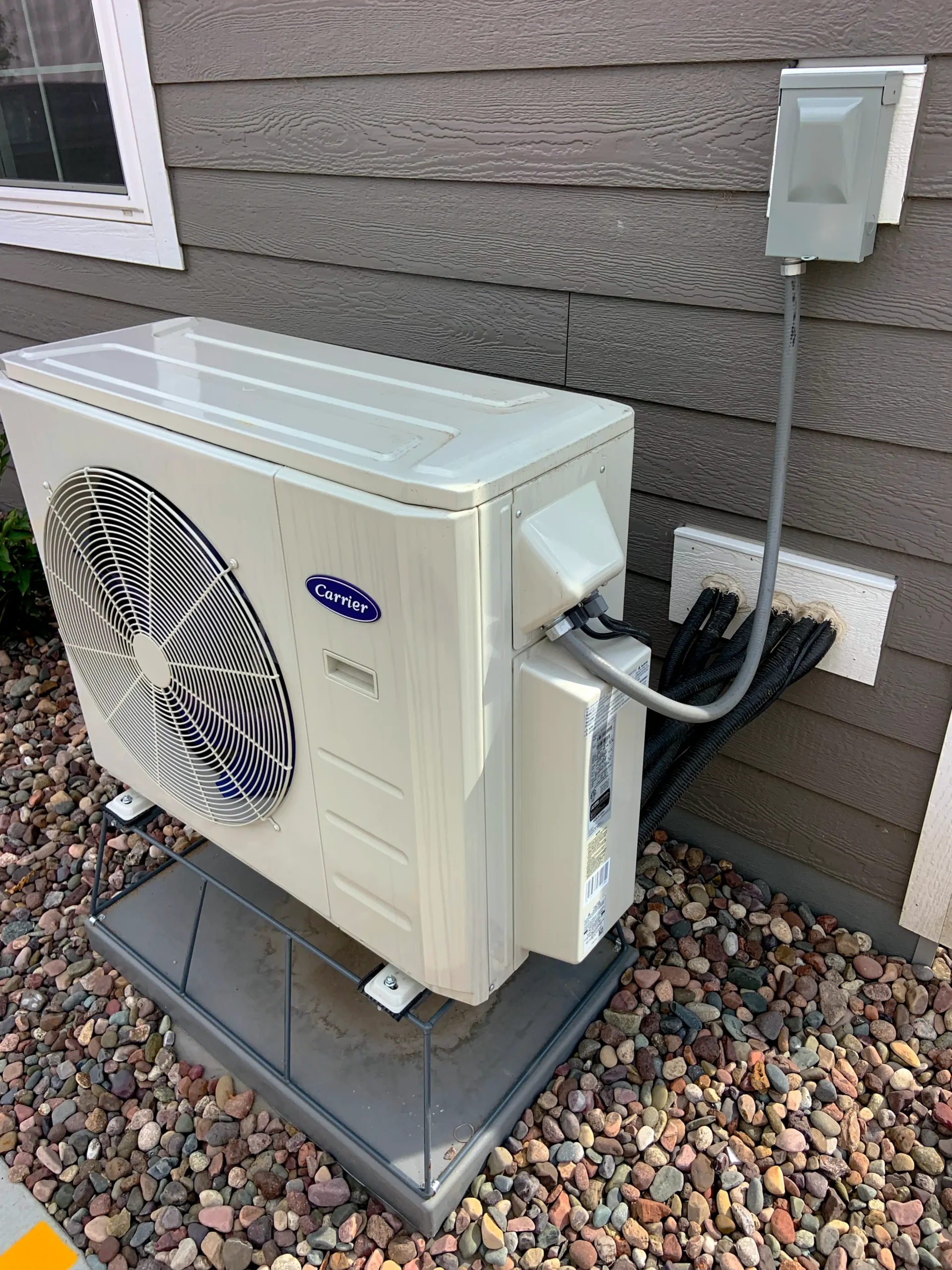 Outdoor heat pump unit beside a home for an Energy Savings Hub guide to home energy upgrades.