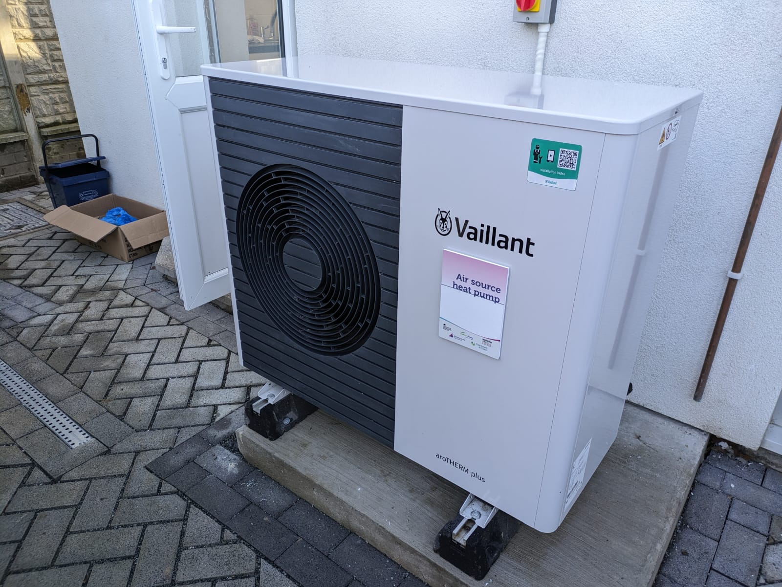Air source heat pump installed outside a residential terraced house.